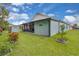 Landscaped backyard featuring an outbuilding for storage, a charming small tree, and green lawn at 2398 Queenswood Cir, Kissimmee, FL 34743