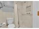 Bright bathroom featuring marble tile, white toilet, and accessible shower at 2398 Queenswood Cir, Kissimmee, FL 34743