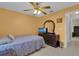 Bedroom showcasing a dresser, TV, queen-sized bed, and ceiling fan with light at 2398 Queenswood Cir, Kissimmee, FL 34743