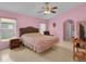 Serene bedroom featuring a comfortable bed, ceiling fan, and a bright window for a tranquil retreat at 2398 Queenswood Cir, Kissimmee, FL 34743