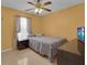 Cozy bedroom featuring a queen-sized bed, tile floors, and a ceiling fan with light at 2398 Queenswood Cir, Kissimmee, FL 34743