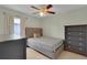 Bedroom with neutral walls, ceiling fan, tile floor, and modern gray furniture at 2398 Queenswood Cir, Kissimmee, FL 34743