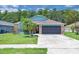Charming single-story home with blue accents, a well-manicured lawn, and a two-car garage at 2398 Queenswood Cir, Kissimmee, FL 34743