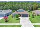 Exterior shot of home and landscaping featuring manicured lawn, flowers, and a two car garage at 2398 Queenswood Cir, Kissimmee, FL 34743
