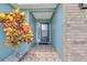 Welcoming front entrance with a colorful croton plant, tile flooring, and neutral paint colors at 2398 Queenswood Cir, Kissimmee, FL 34743