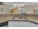 Kitchen bar with stainless steel sink, granite countertops, and pendant lighting at 2398 Queenswood Cir, Kissimmee, FL 34743