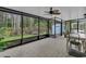 Enclosed, screened porch with tile flooring, offering serene views of lush landscaping at 2398 Queenswood Cir, Kissimmee, FL 34743