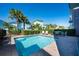 Sparkling pool with outdoor seating and lush green landscaping surrounded by colorful houses at 2938 Salted Rim Rd, Kissimmee, FL 34747
