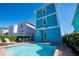 Relaxing pool area with lounge chairs, dining table, and colorful beach home views at 2938 Salted Rim Rd, Kissimmee, FL 34747