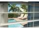 View of a pool area with lounge chairs and colorful buildings through a window at 2938 Salted Rim Rd, Kissimmee, FL 34747