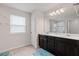 Bathroom featuring a double vanity with dark cabinets and a well-lit mirror and bright lighting at 3084 Slough Creek Dr, Kissimmee, FL 34744