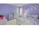 Charming bedroom with lilac walls, a white bed, and decorative elements at 3084 Slough Creek Dr, Kissimmee, FL 34744