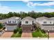 Two-story home with a brick paver driveway and manicured lawn, nestled between two similar properties at 3084 Slough Creek Dr, Kissimmee, FL 34744