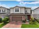 Two-story home with a brick paver driveway, two car garage, neutral siding, and manicured landscaping at 3084 Slough Creek Dr, Kissimmee, FL 34744