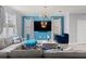 Comfortable living room featuring a gray sectional, blue accents, TV, and bright windows at 3084 Slough Creek Dr, Kissimmee, FL 34744