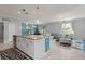 Open floor plan showcasing kitchen island, dining area, and living room with a plush sectional at 3084 Slough Creek Dr, Kissimmee, FL 34744