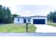 Inviting single-story home showcasing manicured front lawn, convenient mailbox, and a sleek, modern garage door at 318 Cocoa Ct, Kissimmee, FL 34758