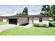 A modern, single-story home boasting a two-car garage, landscaped yard, and a walkway leading to the front door at 318 Cocoa Ct, Kissimmee, FL 34758