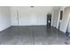 The empty garage has an epoxy floor, multiple doors, and a water heater at 318 Cocoa Ct, Kissimmee, FL 34758