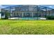 Spacious backyard view of the screened-in pool and patio area at 3341 Pawleys N Loop, St Cloud, FL 34769