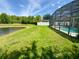 Lush backyard with screened-in pool and a serene lake view at 3341 Pawleys N Loop, St Cloud, FL 34769