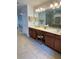 Bathroom showcasing dual sinks, modern lighting, and a walk-in shower with glass doors at 3341 Pawleys N Loop, St Cloud, FL 34769