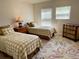 Cozy bedroom featuring two twin beds, a floral rug, and natural light from the windows at 3341 Pawleys N Loop, St Cloud, FL 34769