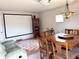 Bonus room featuring a projector screen, dining table, and sectional sofa at 3341 Pawleys N Loop, St Cloud, FL 34769