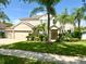 Charming two-story home featuring a well-manicured lawn and lush tropical landscaping at 3341 Pawleys N Loop, St Cloud, FL 34769