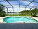 Inviting pool with a spa, screened enclosure, and a serene lake view, perfect for relaxation at 3341 Pawleys N Loop, St Cloud, FL 34769