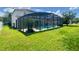 Backyard features a screened pool with a view of the home and green space at 3341 Pawleys N Loop, St Cloud, FL 34769