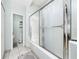 Bathroom with a glass shower door, a white tub, and a separate toilet area at 3928 Blackberry Cir, St Cloud, FL 34769