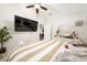 Bedroom featuring white walls, striped bedding, ceiling fan, and mounted TV at 3928 Blackberry Cir, St Cloud, FL 34769