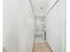 Hallway featuring a distant view of bathroom with a glass shower door and multiple storage closets at 3928 Blackberry Cir, St Cloud, FL 34769