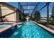 Backyard screened pool and hot tub with a tranquil water feature and a lush landscape at 3928 Blackberry Cir, St Cloud, FL 34769