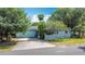 Charming home exterior with a garage and driveway, surrounded by lush greenery at 401 Maryland Ave, St Cloud, FL 34769