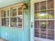 Close-up view of a light blue home with a vintage-style front door and window at 401 Maryland Ave, St Cloud, FL 34769