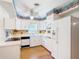 Traditional kitchen with white cabinetry, hardwood floors, and fish-themed decor at 401 Maryland Ave, St Cloud, FL 34769