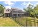Fenced backyard featuring a screened-in pool, patio area, and lush greenery at 430 Bywater Dr, Orlando, FL 32839