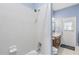 Full bath with white tiled shower and blue accent wall, wooden vanity, and access to the backyard at 430 Bywater Dr, Orlando, FL 32839