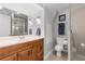 This is a full bathroom featuring a wood vanity, large mirror, and tiled shower at 430 Bywater Dr, Orlando, FL 32839