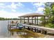 Lakefront dock with boat and jet ski lifts, a seating area, and beautiful water views at 430 Bywater Dr, Orlando, FL 32839