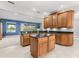 Kitchen featuring an island, granite countertops, wood cabinets, and an open view into the living room at 430 Bywater Dr, Orlando, FL 32839