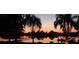 Enjoy the serene sunset over the lake with palm trees and a small boat dock at 430 Bywater Dr, Orlando, FL 32839