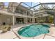 Backyard view showcasing a screened-in pool with an attached spa and a covered patio area at 430 Bywater Dr, Orlando, FL 32839