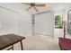 Cozy bedroom featuring carpet floors, a ceiling fan, built-in shelves, and Murphy bed for flexible living at 4700 Buggywhip Ln # 102, Orlando, FL 32812