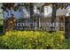Entrance to the community with manicured landscaping, mature trees, brick pillars, and visible signage at 4700 Buggywhip Ln # 102, Orlando, FL 32812