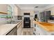 Bright kitchen features neutral cabinetry, black appliances, and a butcher block island at 4700 Buggywhip Ln # 102, Orlando, FL 32812
