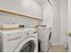 Bright laundry room features a washer, dryer, and upper cabinets at 4700 Buggywhip Ln # 102, Orlando, FL 32812