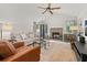Inviting living room with vaulted ceilings, a cozy brick fireplace, and ample natural light from large windows at 4700 Buggywhip Ln # 102, Orlando, FL 32812